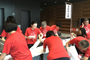 来場者へ渡す配布物の梱包と、受付の支援を行う社員ボランティア